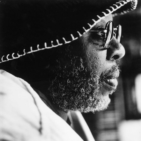 an older black man with a hat and glasses, facing right.